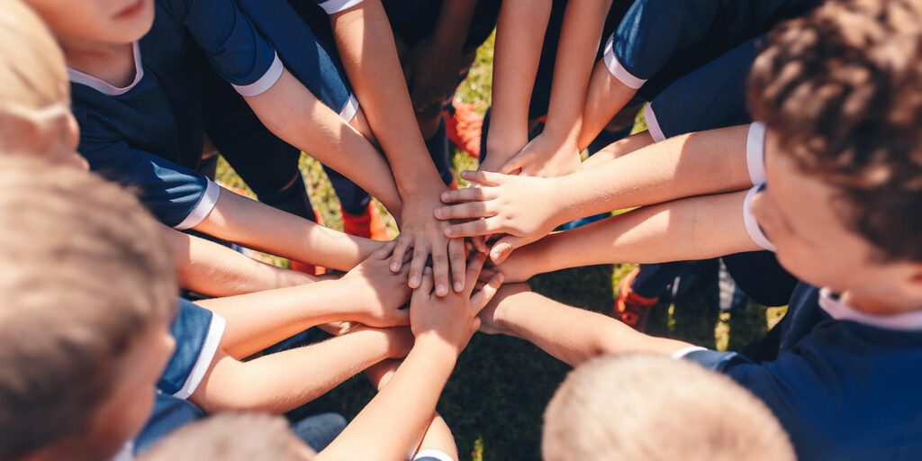 Team hands in the center for a cheer.